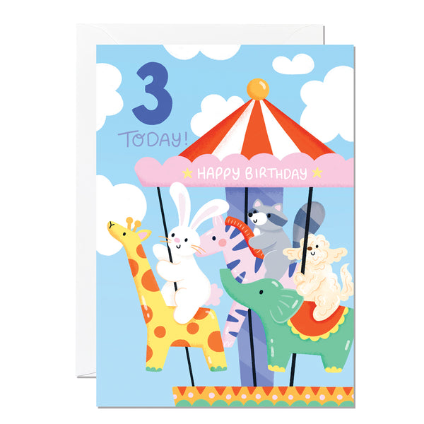 A colourful birthday card featuring an illustration of a carousel with a giraffe, rabbit, pig, and cat riding on it. The card indicates it's a 3rd birthday card and says 'Happy Birthday'.