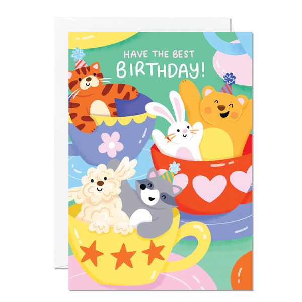 A colourful birthday card featuring cartoon animals having fun on the teacups ride at the funfair, with a 'Happy Birthday' message.