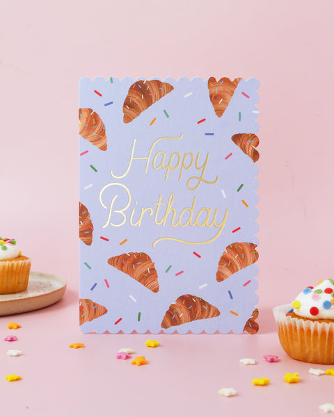 Birthday card with croissant design and 'Happy Birthday' text on a pink background