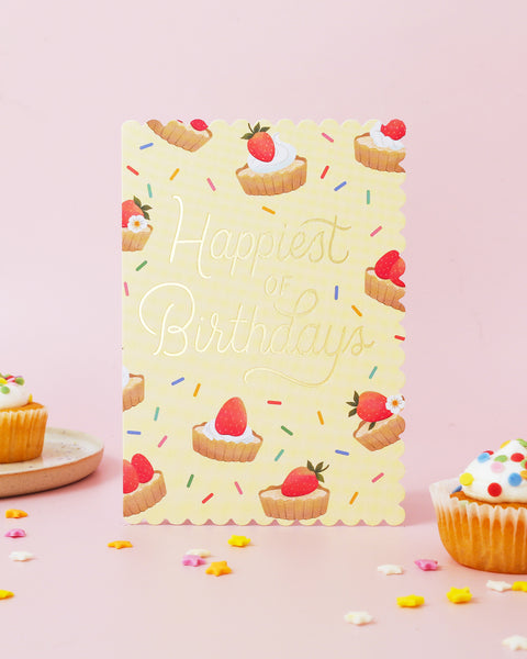 Birthday card with strawberry tarts and 'Happiest of Birthdays' text on a yellow background