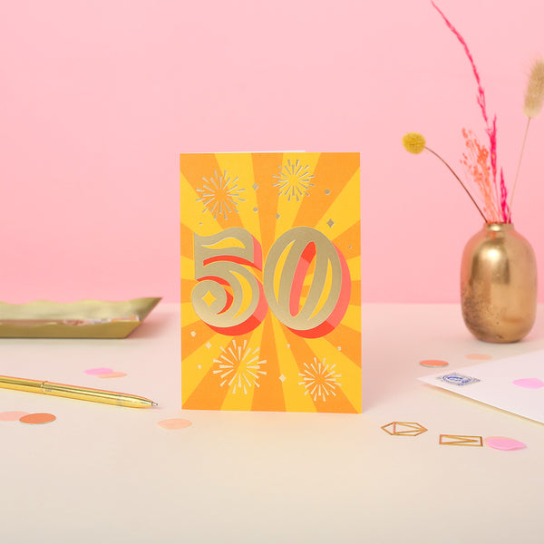 A 50th birthday card with gold foil text and a colourful background, indicating the number 50 with a golden hue.