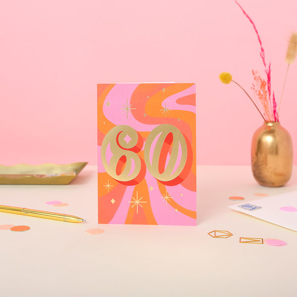 A 60th birthday card with a colourful design, featuring gold foil, orange, pink, and yellow colours, and the number 60.