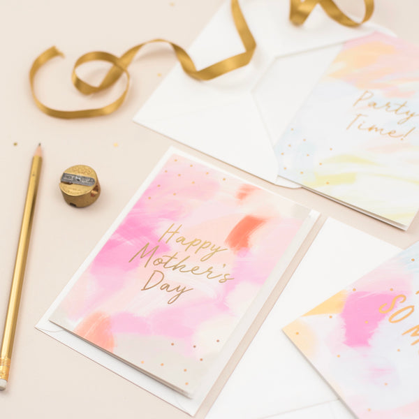 A mother's day card featuring a hand-painted canvas background and gold foil lettering that says 'happy mother's day'