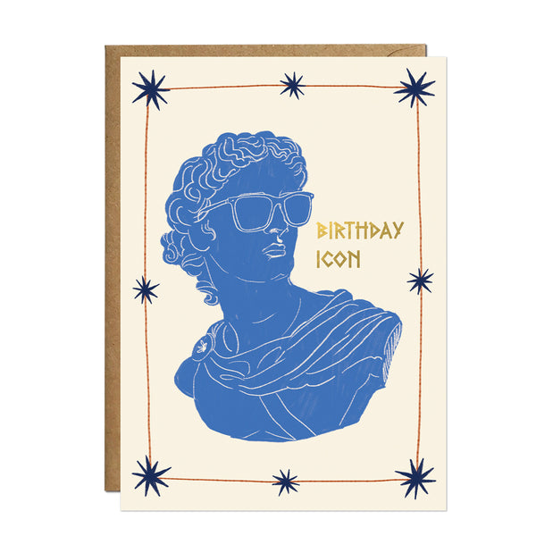 A chic cream birthday card displaying a silhouette of a blue Greek bust wearing sleek sunglasses, surrounded by delicate gold stars and elegant typography.