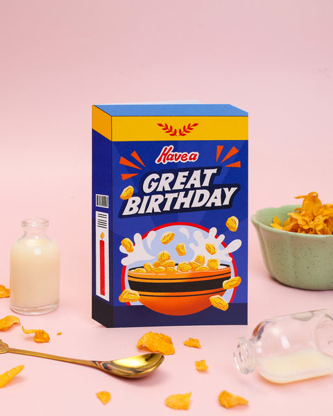 A die-cut birthday card featuring a honey-nut cereal box design with yellow and black bumblebee stripes, a honey dipper, and a bowl of crunchy cereal.