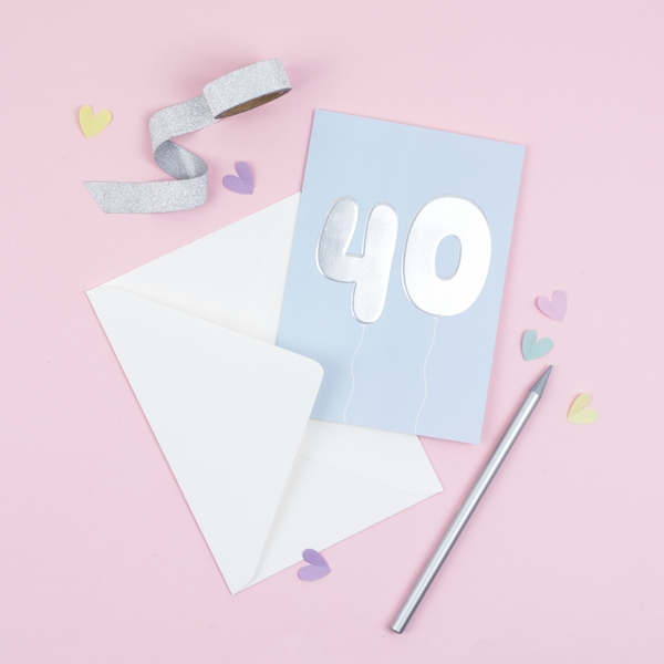 A 40th birthday card featuring big helium balloons printed with an embossed silver foil on a blue card.