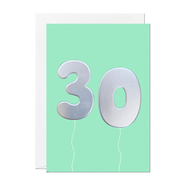 A 30th birthday card with birthday balloons that have been printed with an embossed silver foil on a mint greeting card
