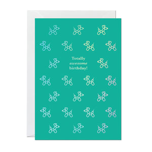 A totally awesome birthday card featuring a pattern of dog balloons on a green background printed with an iridescent foil