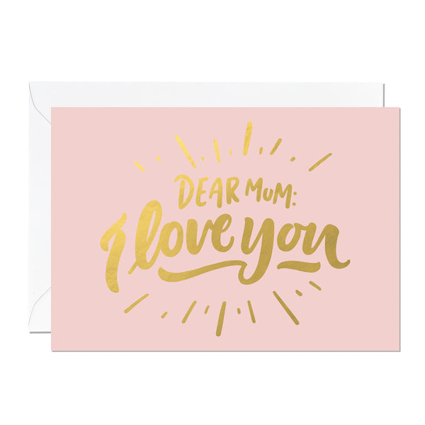This is a Mother's Day card that says 'Dear Mum: I Love You'. It's printed with a light pink background and features hand lettering printed with a luxury gold foil