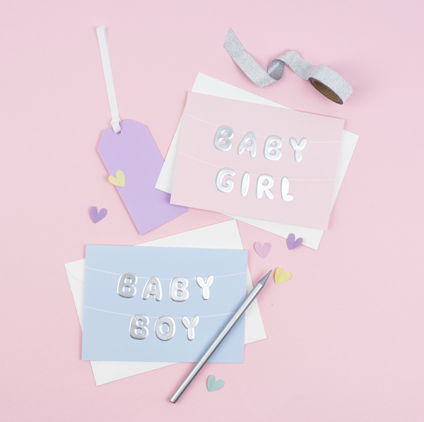 A pink baby girl greeting card featuring letter bunting printed with an embossed foil
